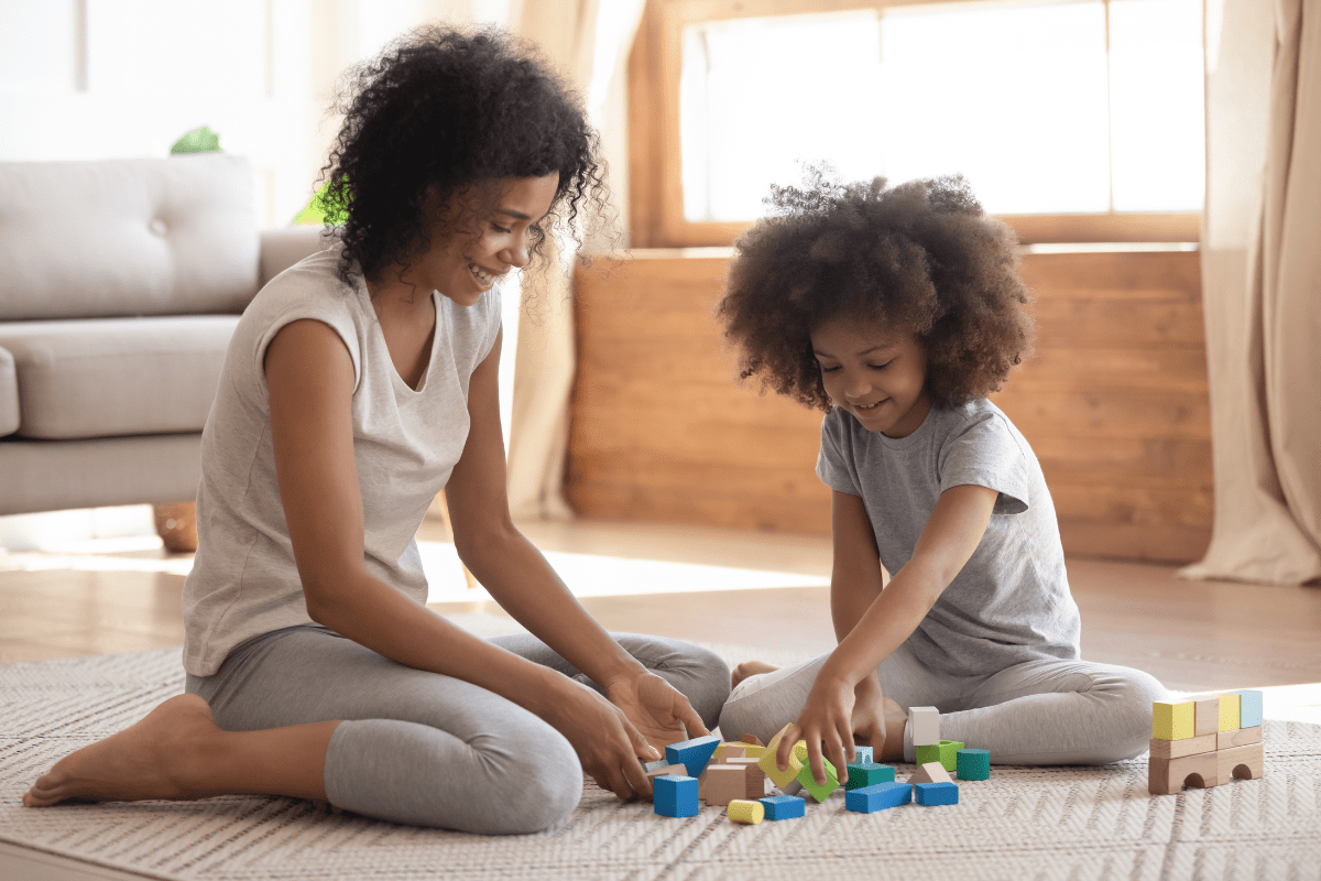 mom and child playing blocks on the floor (special time)