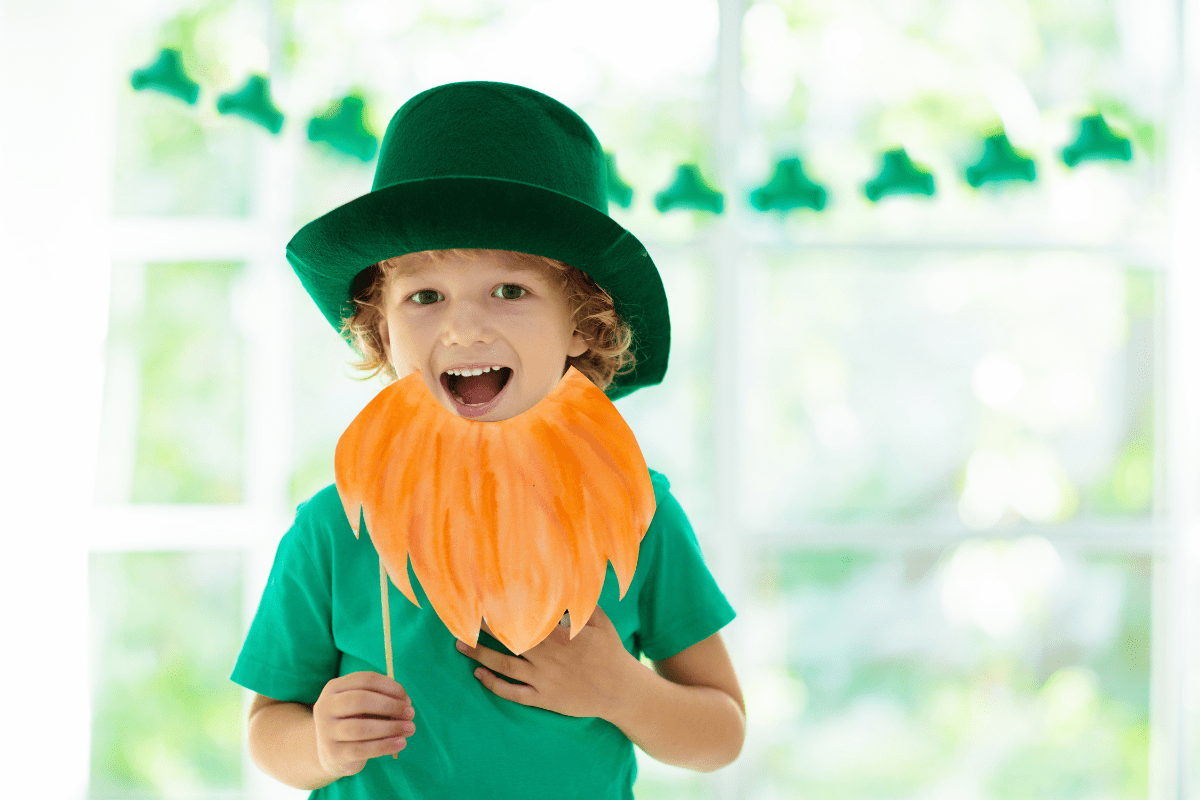 child wearing green shirt, green hat, and pretend leprechaun beard to celebrate St. Patrick's Day