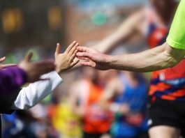 Boston Marathon runners high fiveing child spectators