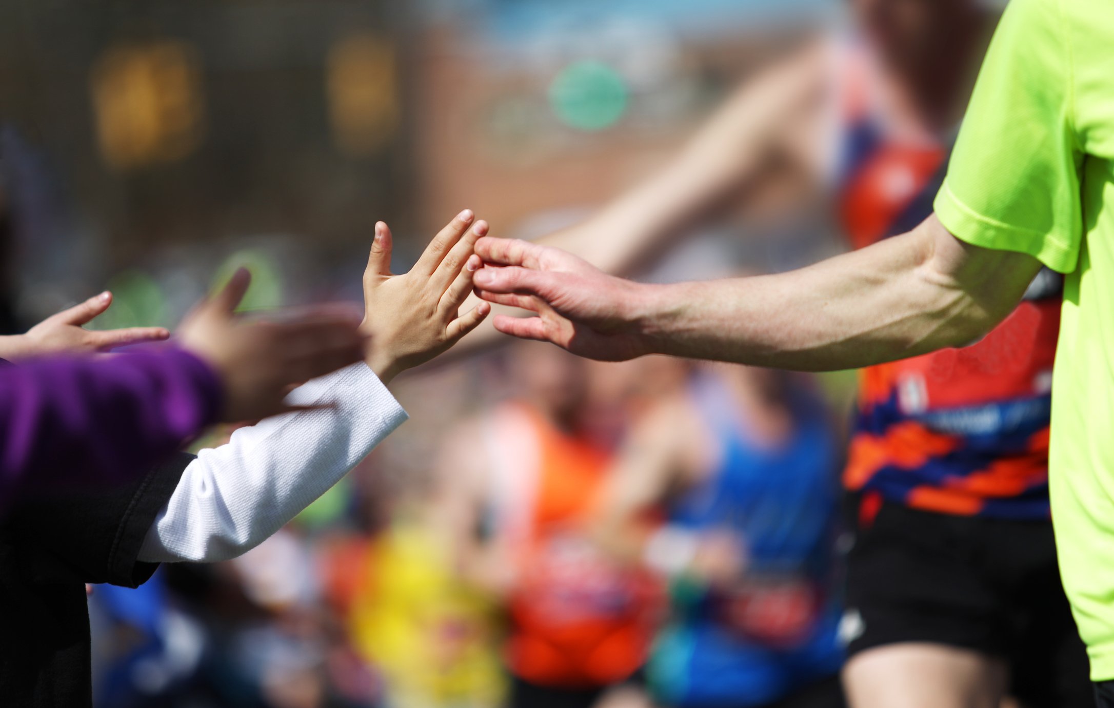 Boston Marathon runners high fiveing child spectators
