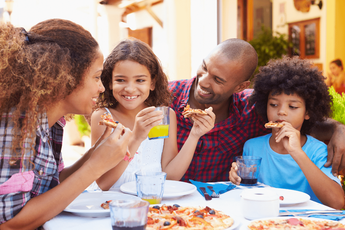 family eating pizza outdoors (best outdoor dining Boston families)