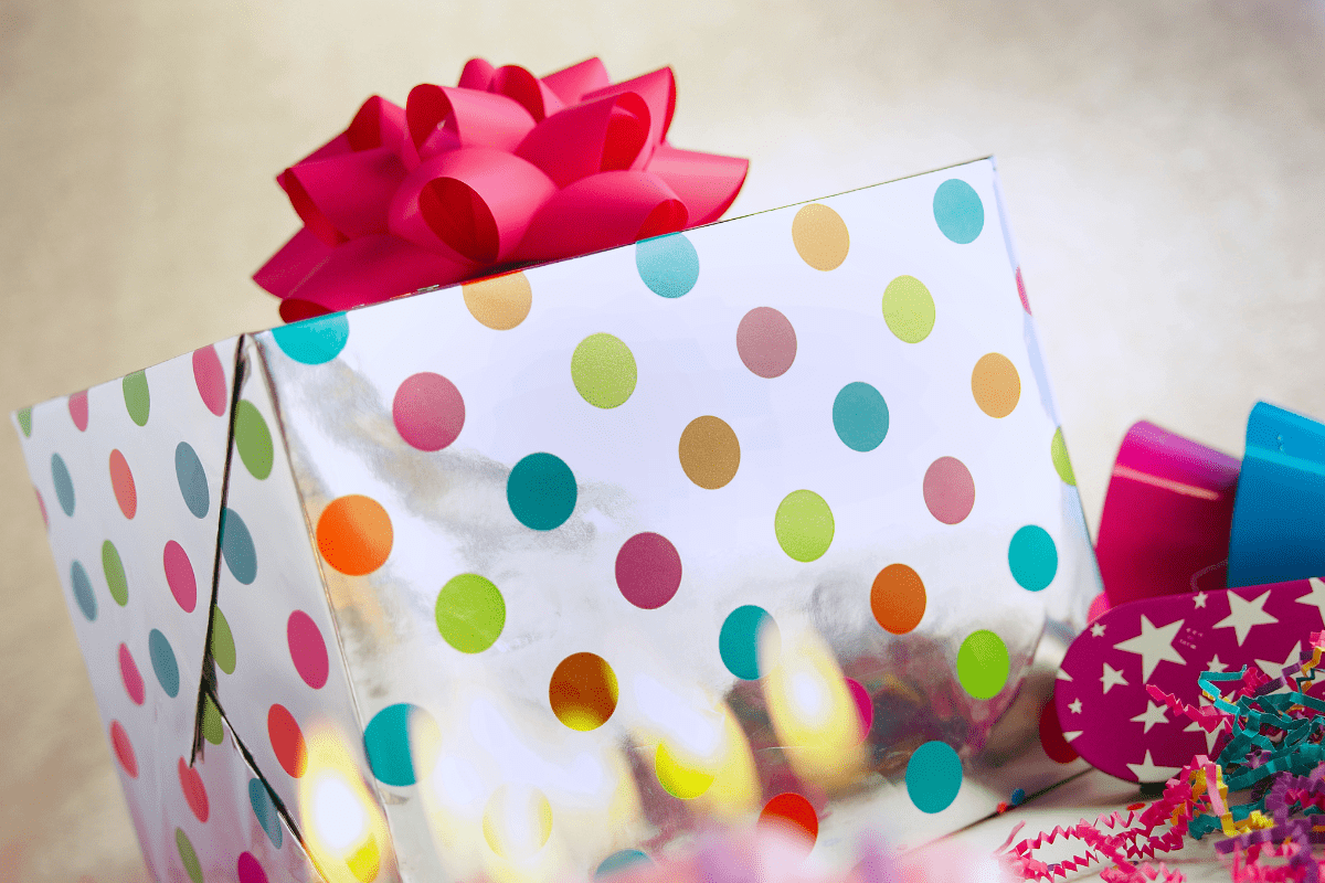 large wrapped gift box with red bow on top, illustrating a list of birthday gift ideas for children
