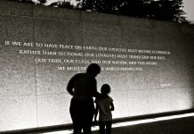 adult and child standing in front of Martin Luther King Jr. quote