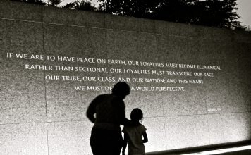 adult and child standing in front of Martin Luther King Jr. quote