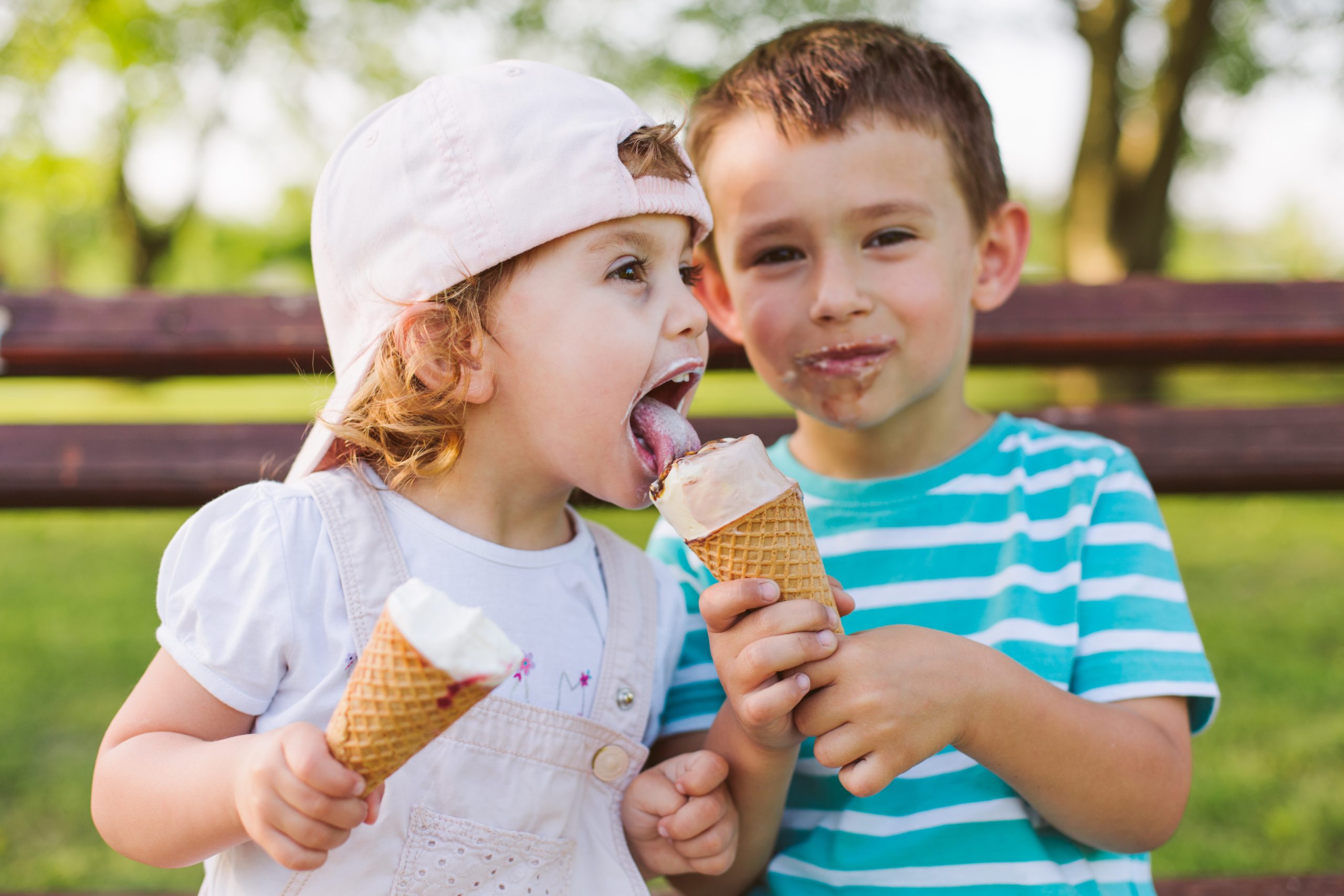 two children close in age sharing ice cream cones (having kids close together)