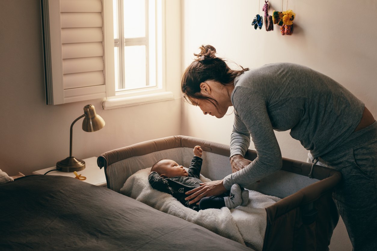 mother putting baby to bed in crib (to the mother whose child doesn't sleep) 