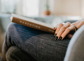 parenting book resting on a woman's lap
