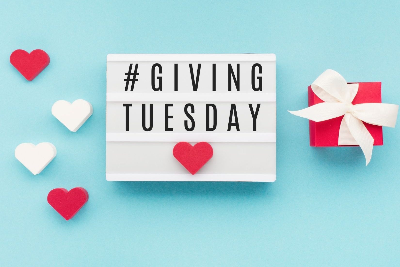 #GivingTuesday on a blue background with red and white hearts.