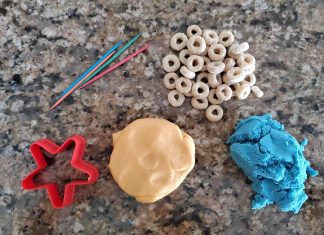 plastic cookie cutter, Cheerios, play dough and kinetic sand