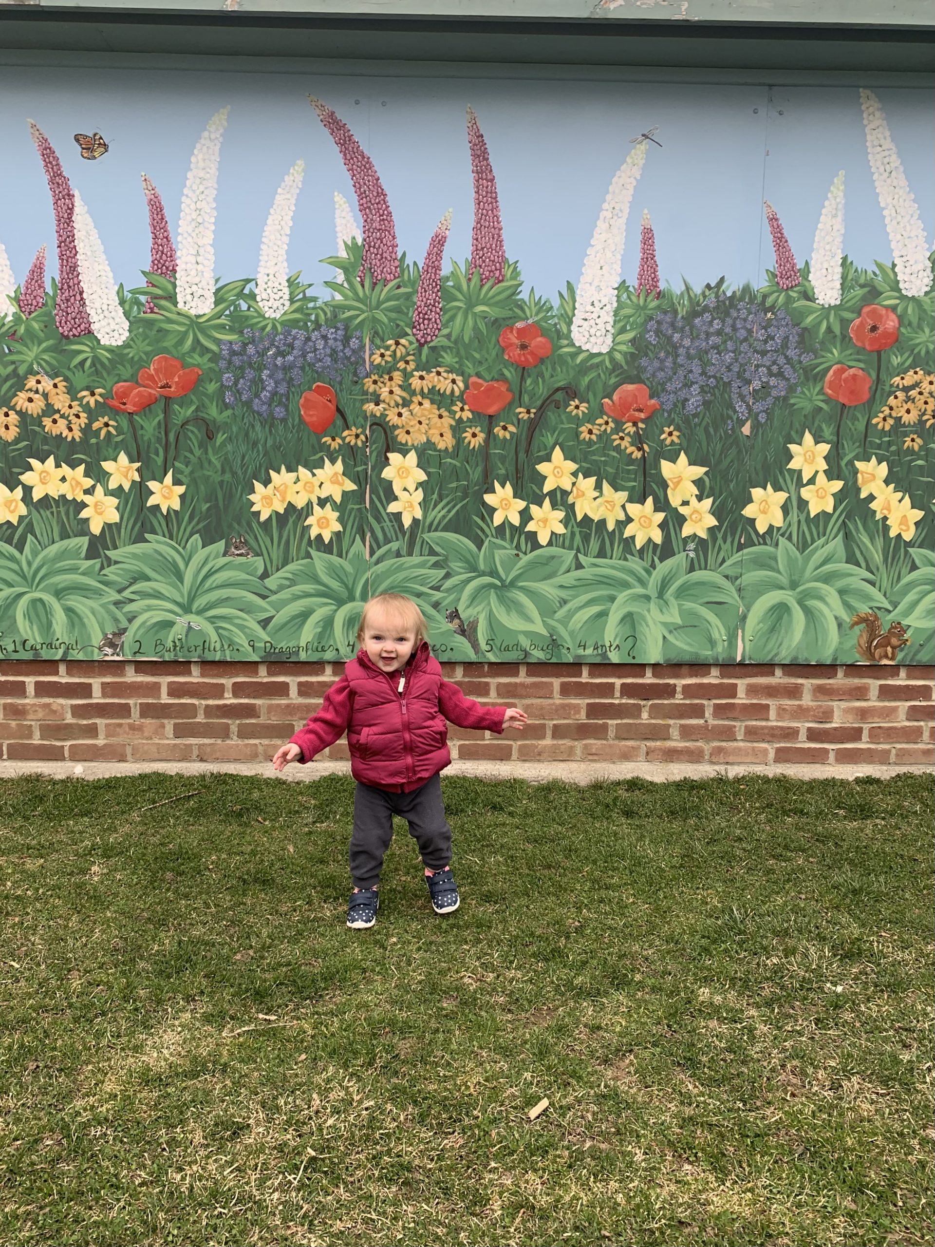 baby in front of mural