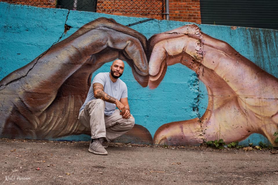 Artist in front of his mural