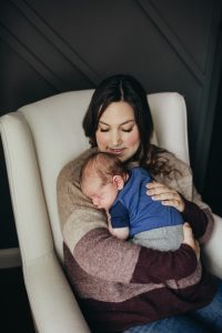 woman holding infant in chair