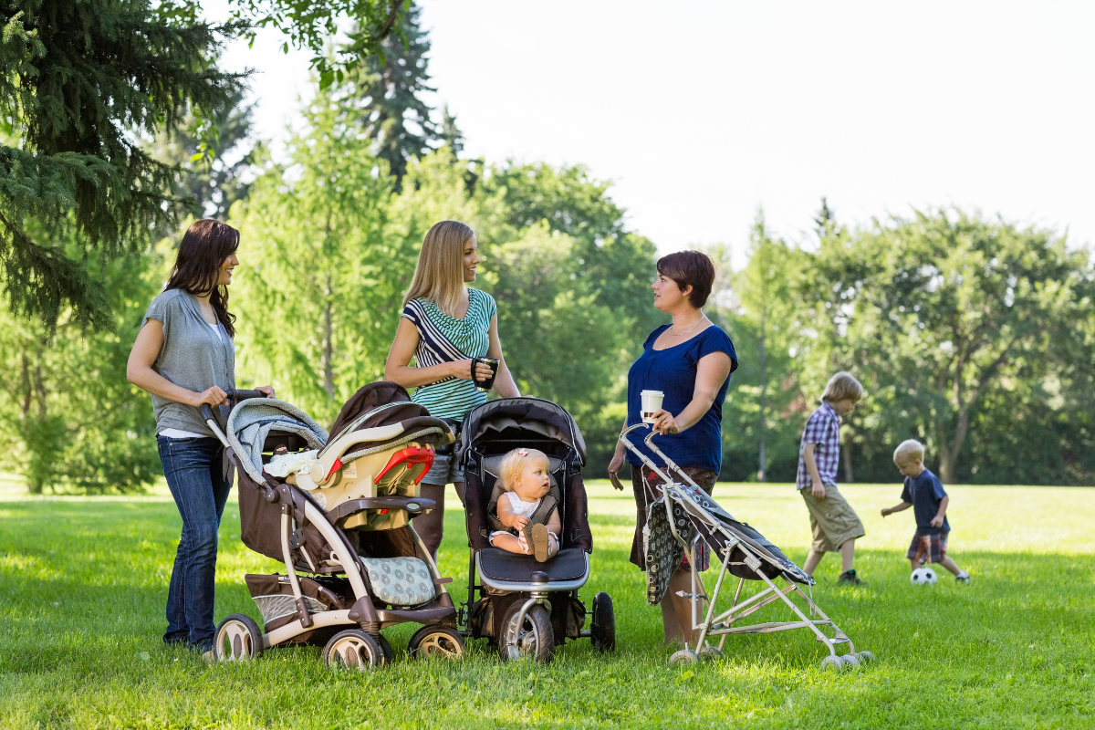three moms talking around their strollers, showing the introvert mom who has found her mom tribe