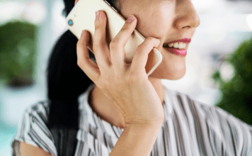 woman holding phone to ear, talking to long-distance friends
