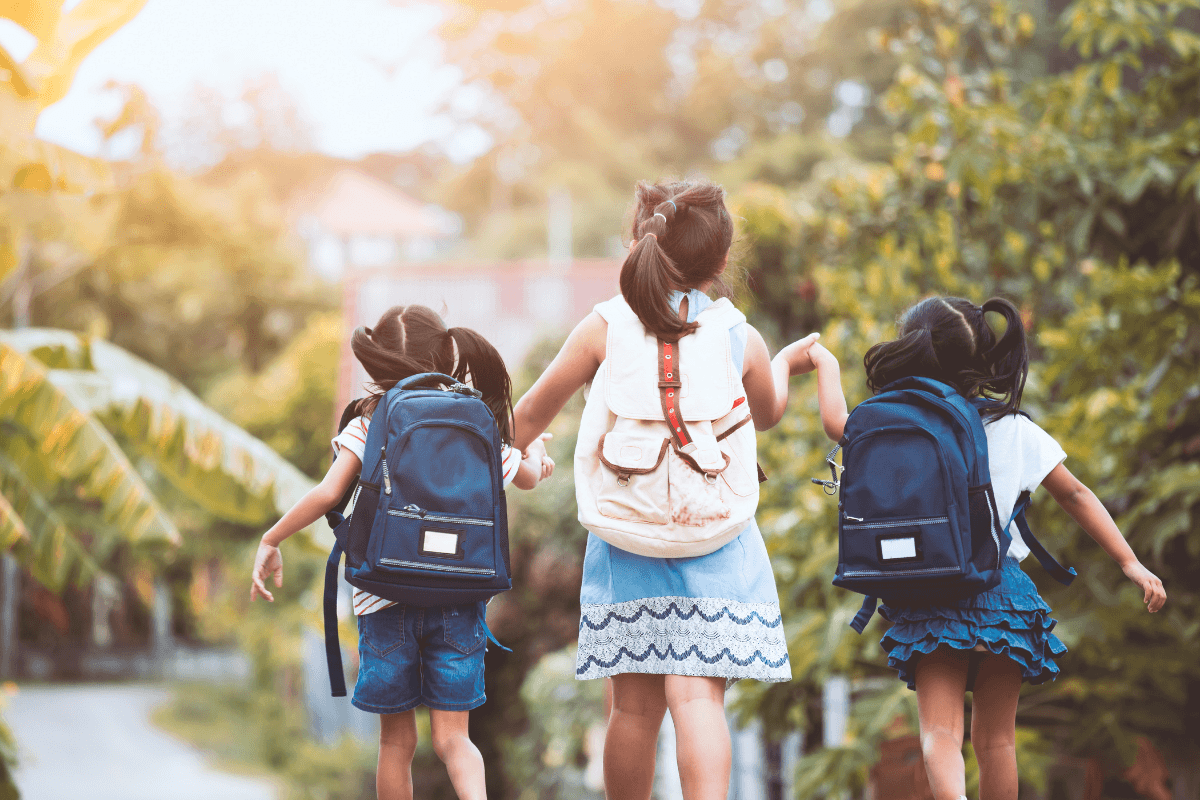 three young girls wearing backpacks