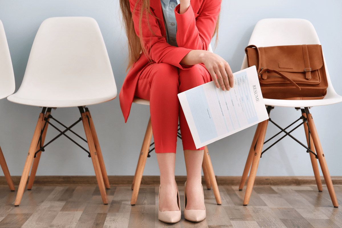 woman sitting on chair holding resume