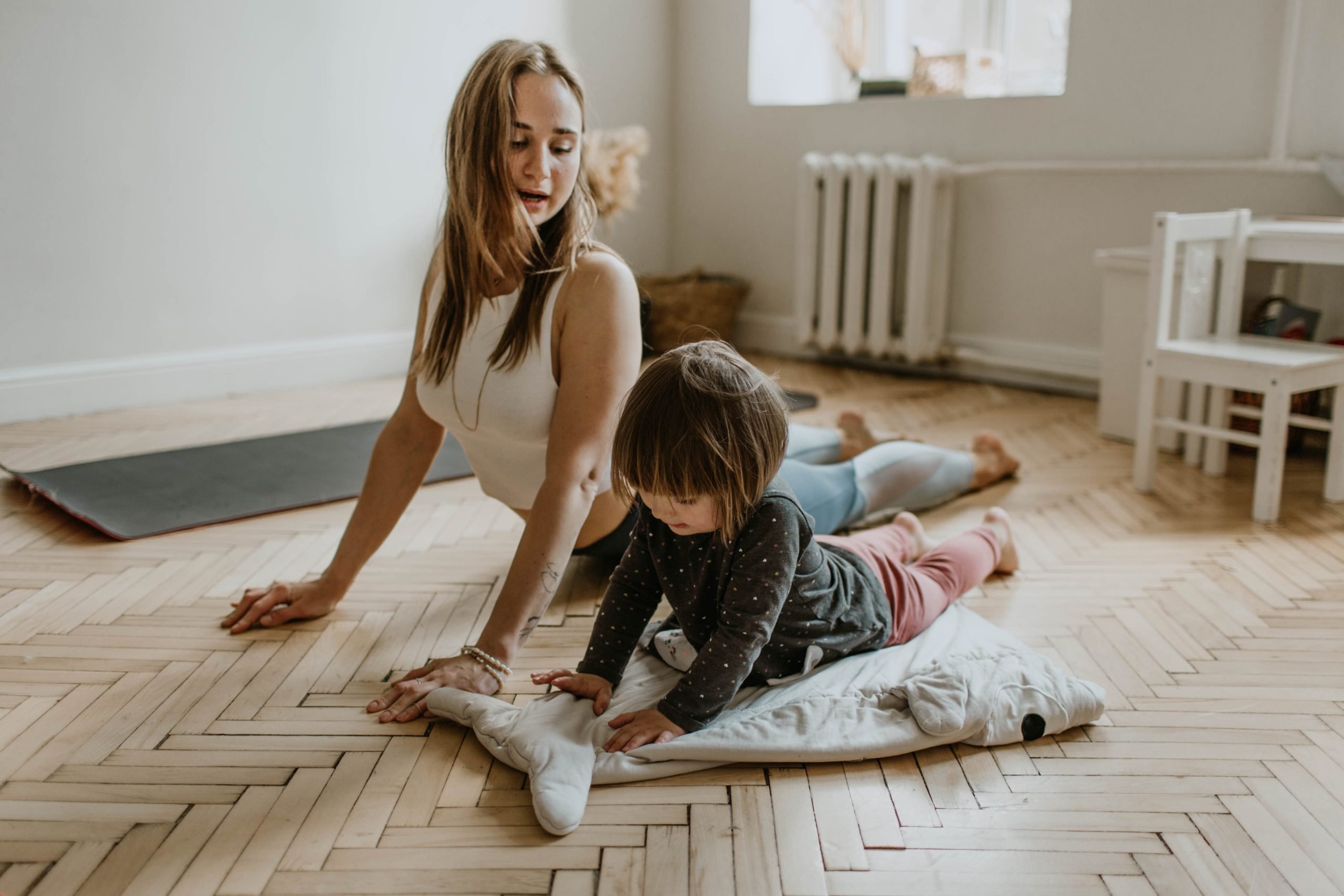 Mother and daughter doing yoga together on floor
