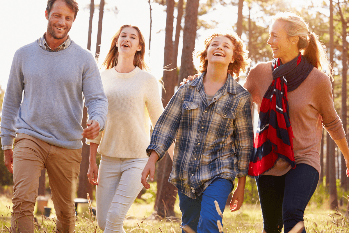 two parents and two teenagers on a walk outdoors (how to have a fun family weekend)